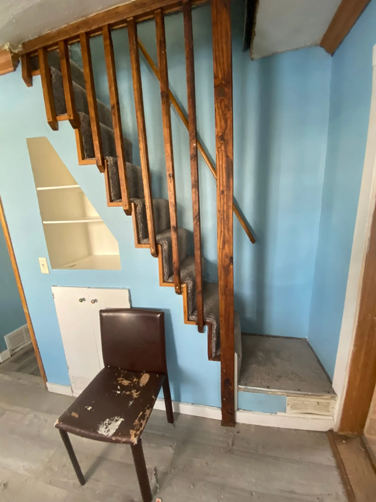 Carpeted stairs with railing and shelving