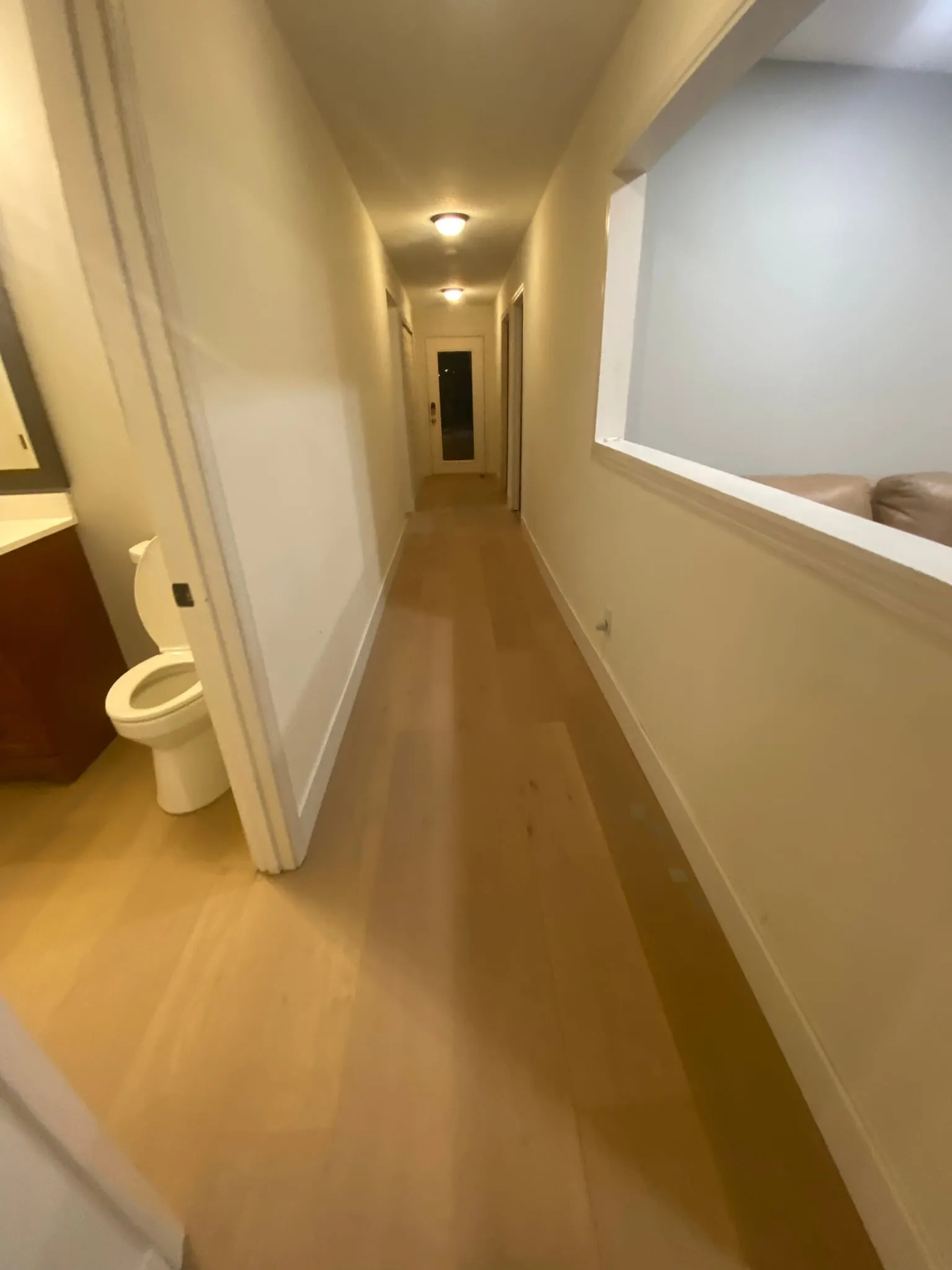 Hallway and bathroom with hardwood flooring