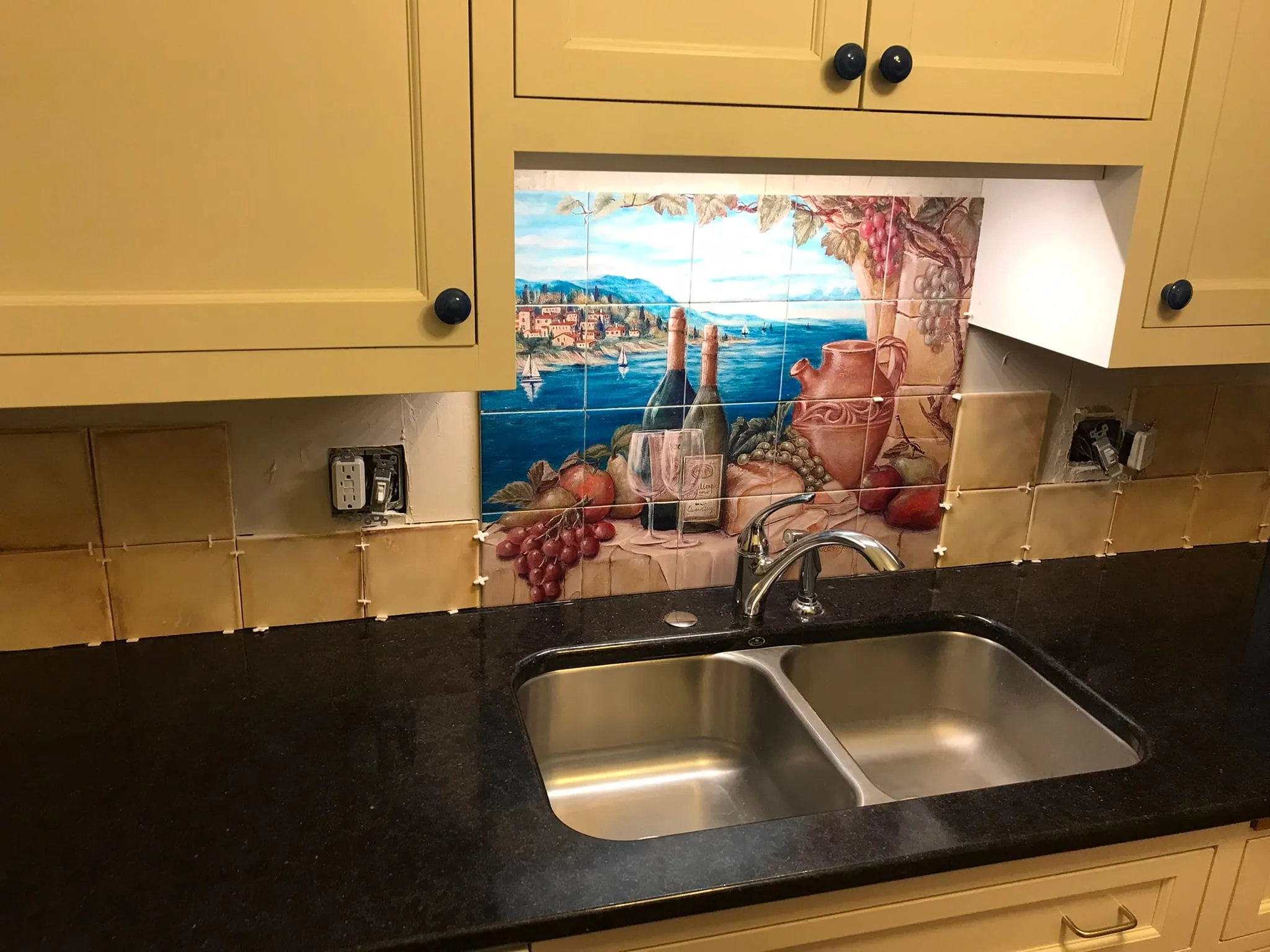 Wine mural tile backsplash above kitchen sink
