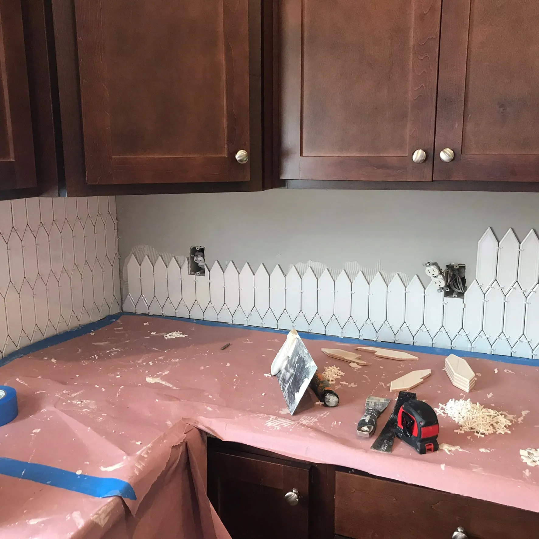 White picket backsplash tile being installed