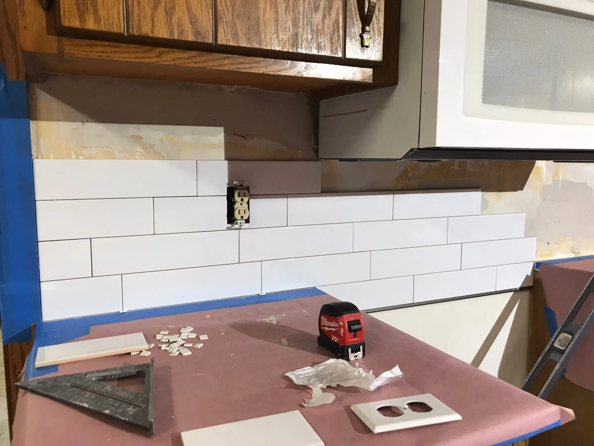 White subway tile backsplash partway installed