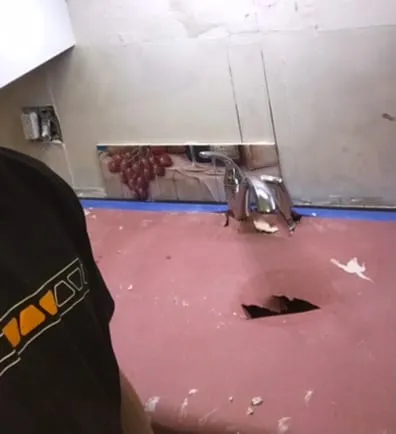 Backsplash demo behind sink, dark cluttered shot