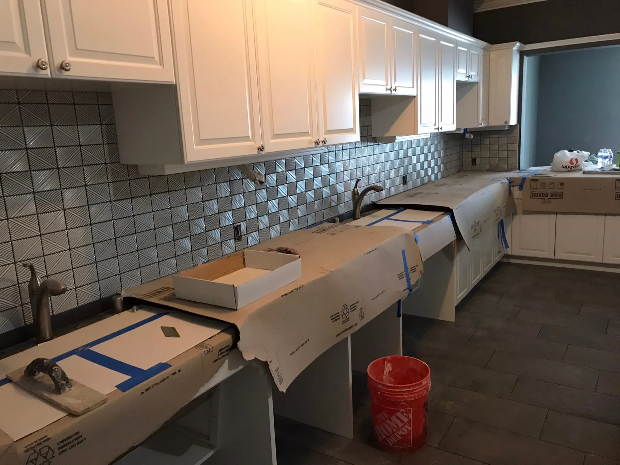 Geometric mosaic backsplash install with covered counters