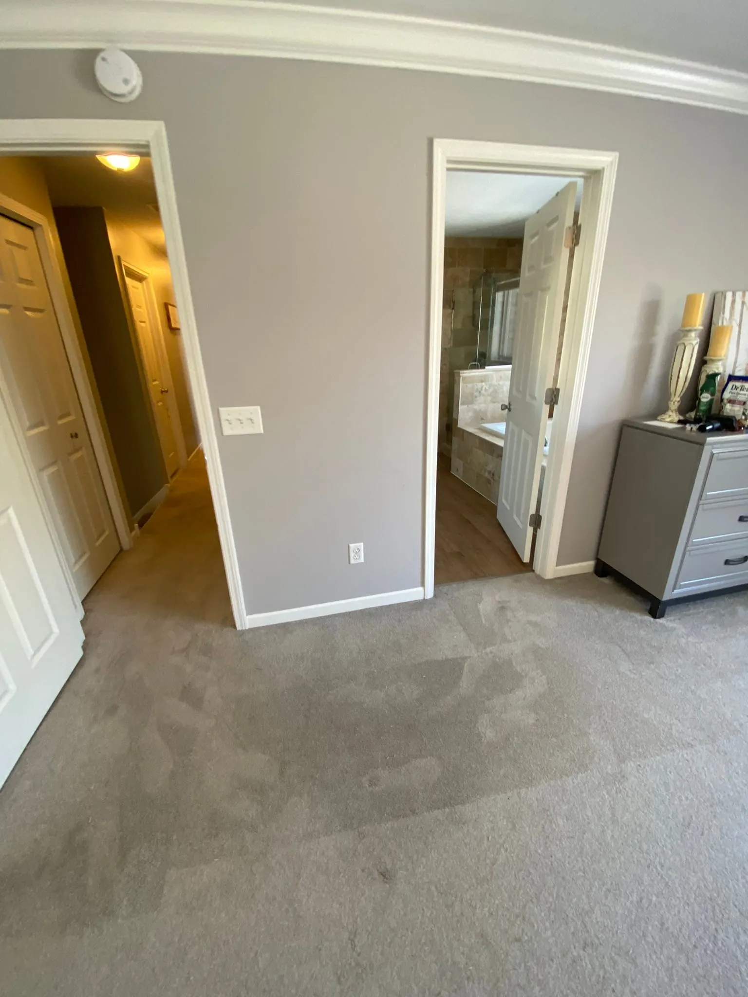Bedroom with carpet leading to tiled bathroom