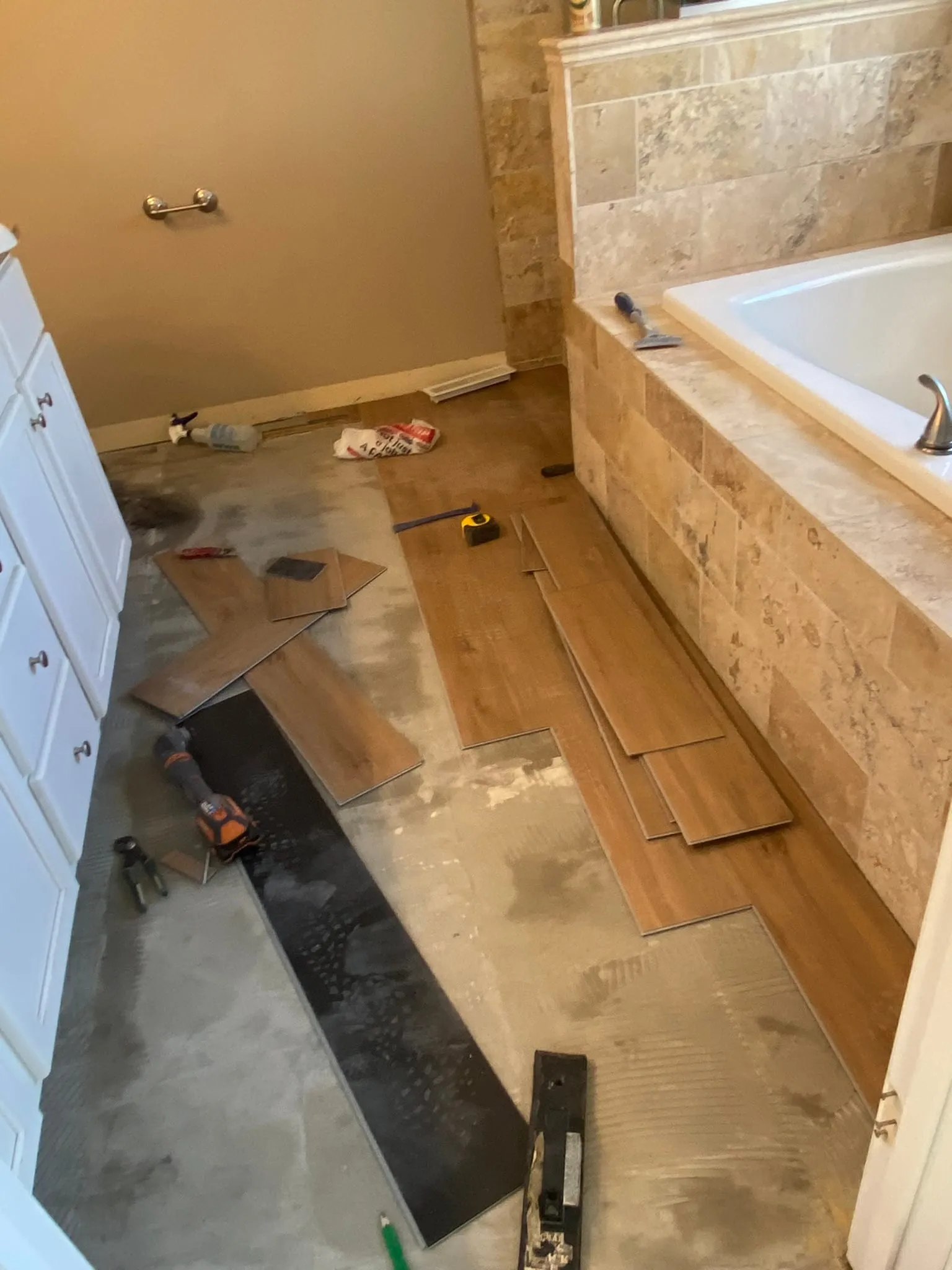 LVP plank flooring installation beside bathtub