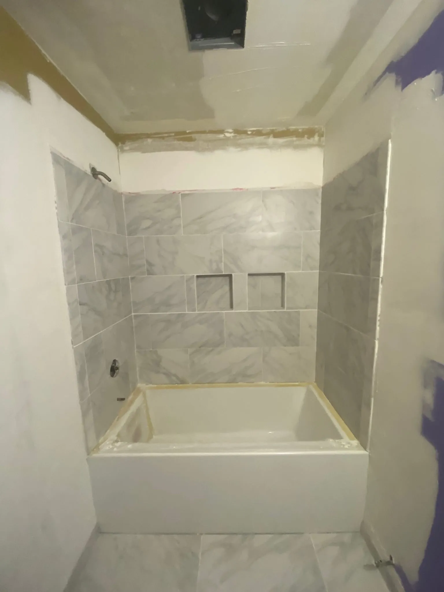 Completed marble tile tub surround with niche