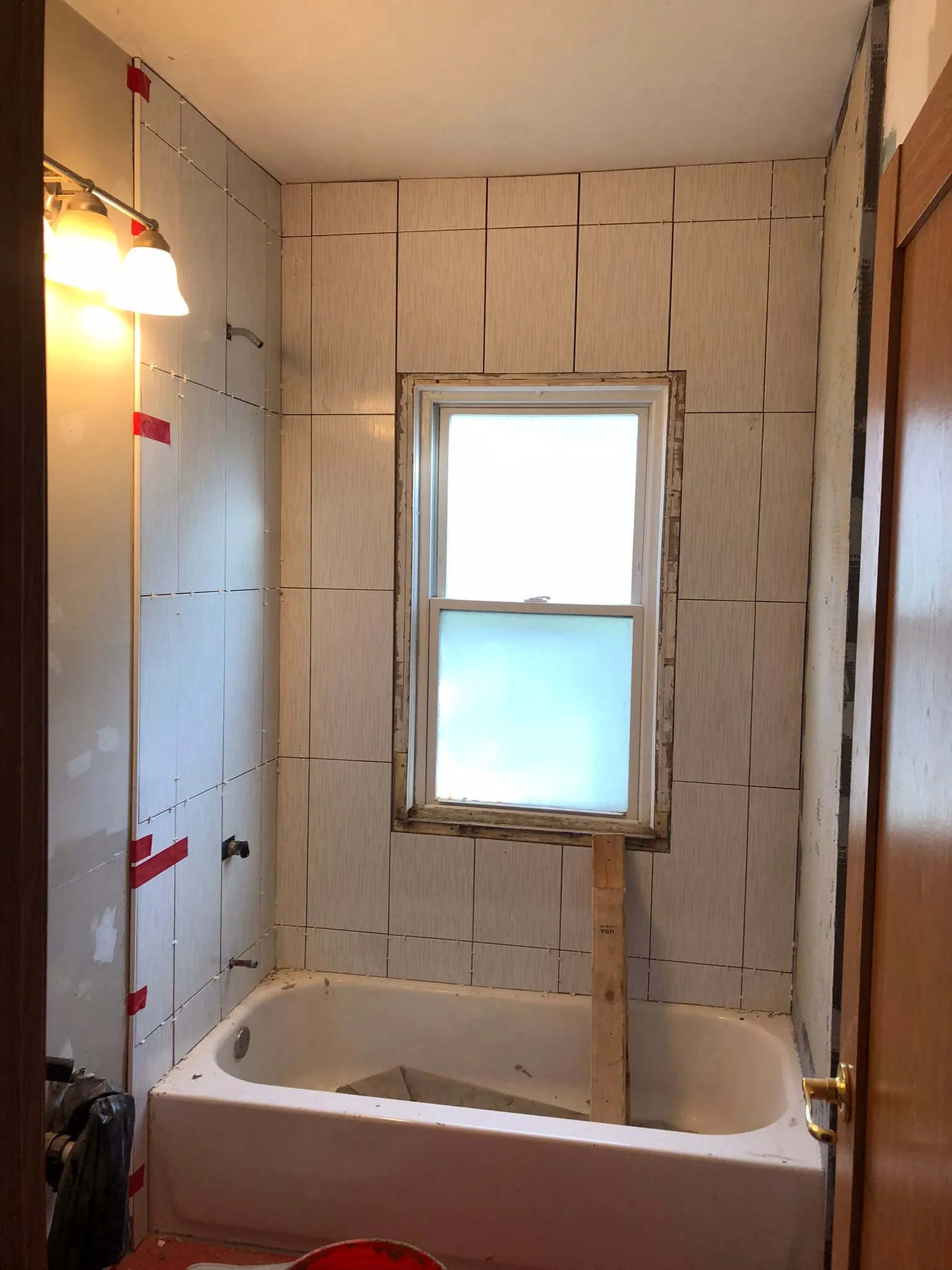 Tub surround tiled around bathroom window