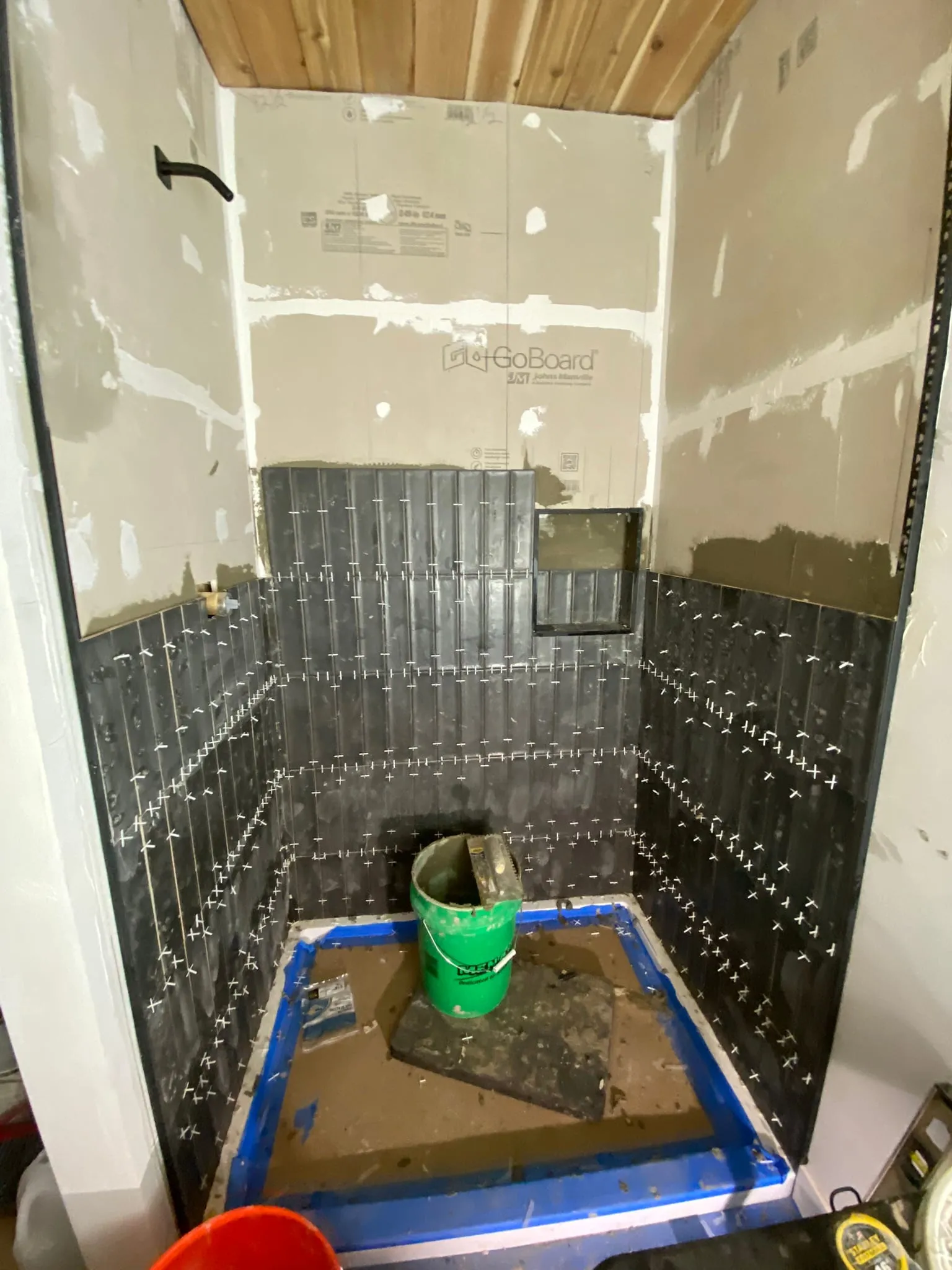 Dark vertical tile shower walls during install